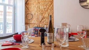 A dining table set with wine glasses, a bottle of wine, and a water jug. - Old Town Chiado Balcony Aircon by LD Apartments (Lisbon)