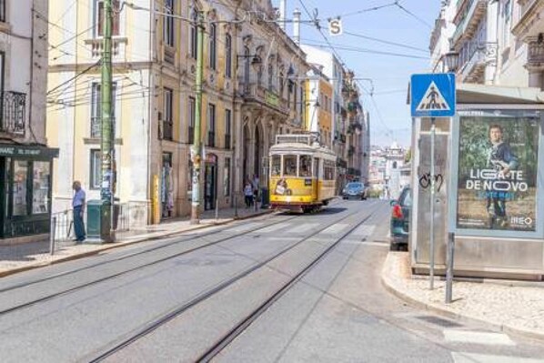 A tram on a city street with buildings on either side.
