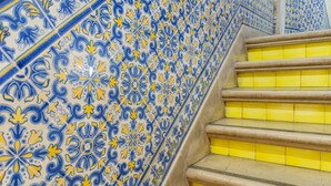 Una escalera con peldaños amarillos y una pared con diseño azul y amarillo.