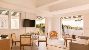 A spacious living area with a dining table, chairs, a sofa, and a TV. - Carla Rosa 10 Luxueux Appartement Piscine -2 BDR (Cannes)
