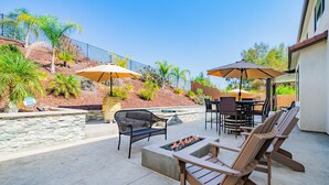 An outdoor patio with seating, a fire pit, and umbrellas. - Allura Champagne New in Wine Country Pool Game Rm (Winchester)