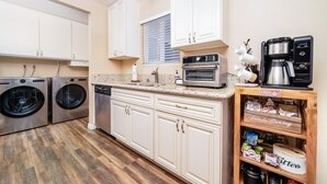 A kitchen with stainless steel appliances, white cabinets, and a coffee station. - Lux - Charming San Marcos 2BR Patio Pet-friendly (San Marcos)