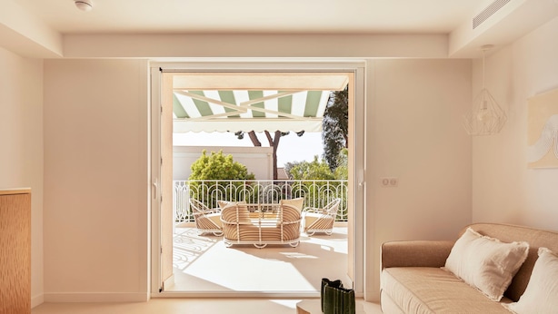 A modern living room with a sliding glass door leading to an outdoor seating area.