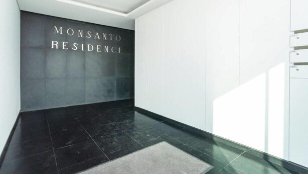 En modern inredning med ett svart kaklat golv och en vägg där det står ”MONSANTO RESIDENCE”.
