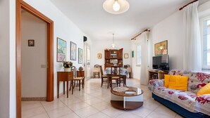 Una sala de estar con sofá, mesa de centro y comedor con sillas y una mesa.