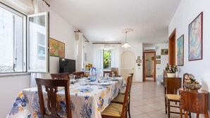 Un comedor con una mesa dispuesta para cuatro personas, rodeada de sillas de madera.