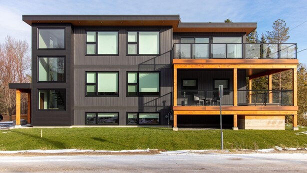 A modern two-story house with large windows, a balcony, and a wooden deck. - High-tech Mountain Luxury Fitness Hot Tub BBQ (The Blue Mountains)