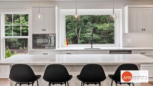 A modern kitchen with a large island, white cabinetry, and pendant lighting. - Destined for Relaxation (Saugatuck)