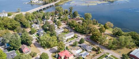 Vista aérea de una zona residencial con casas, un muelle y un puente sobre un lago.