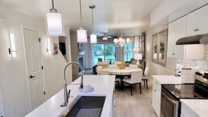 A modern kitchen with a central island, stainless steel appliances, and pendant lighting. - Charming Bayview - Downtown Condo With Pool (Saugatuck)