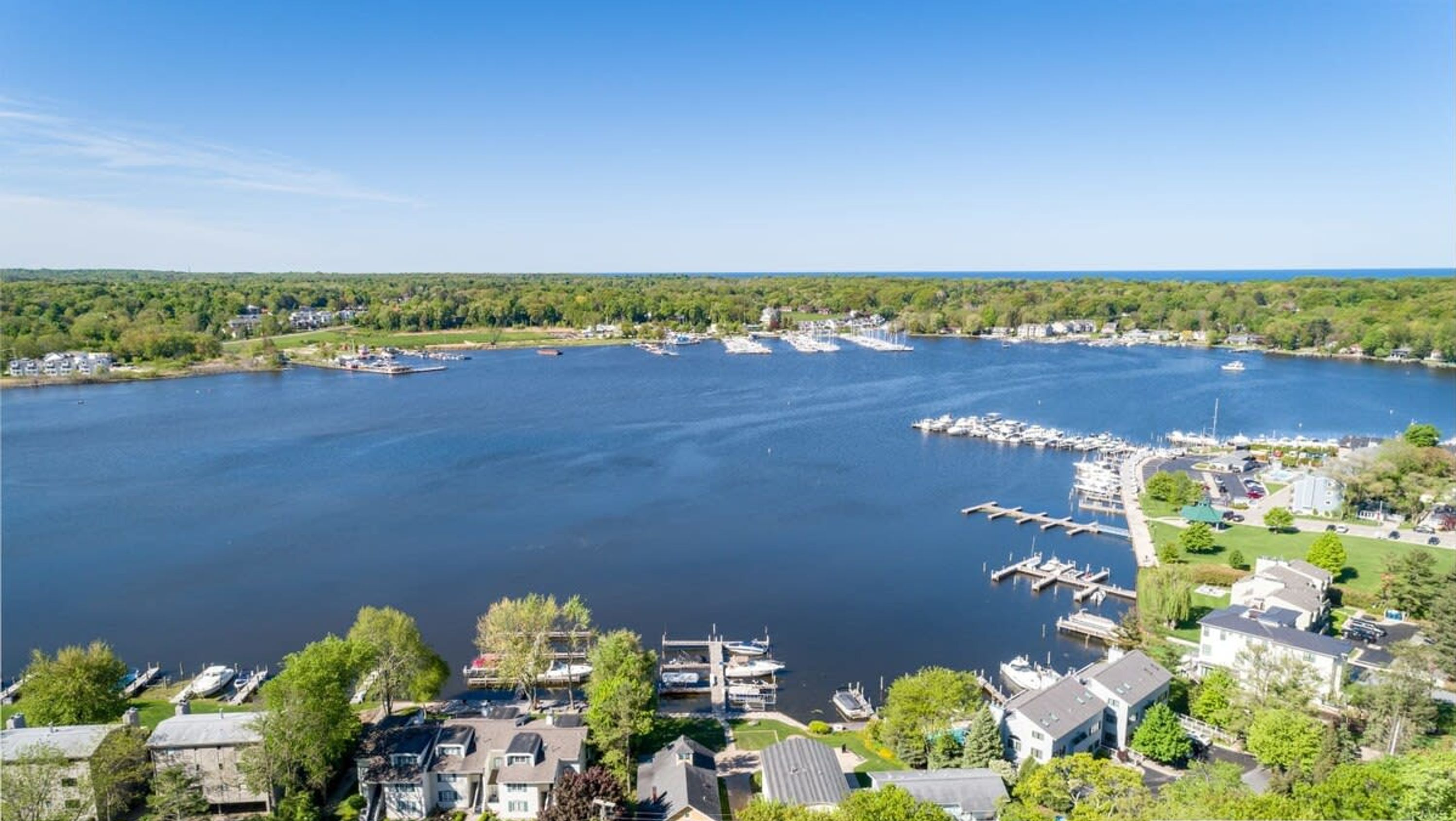 A marina with boats docked, surrounded by residential buildings and greenery.