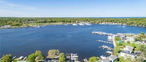 A marina with boats docked, surrounded by residential buildings and greenery.