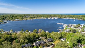 An aerial view of a lakeside community with houses, docks, and a marina. - Charming Bayview - Downtown Condo With Pool (Saugatuck)