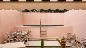 Un'accogliente area patio con piscina, poltrona relax e tavolo.