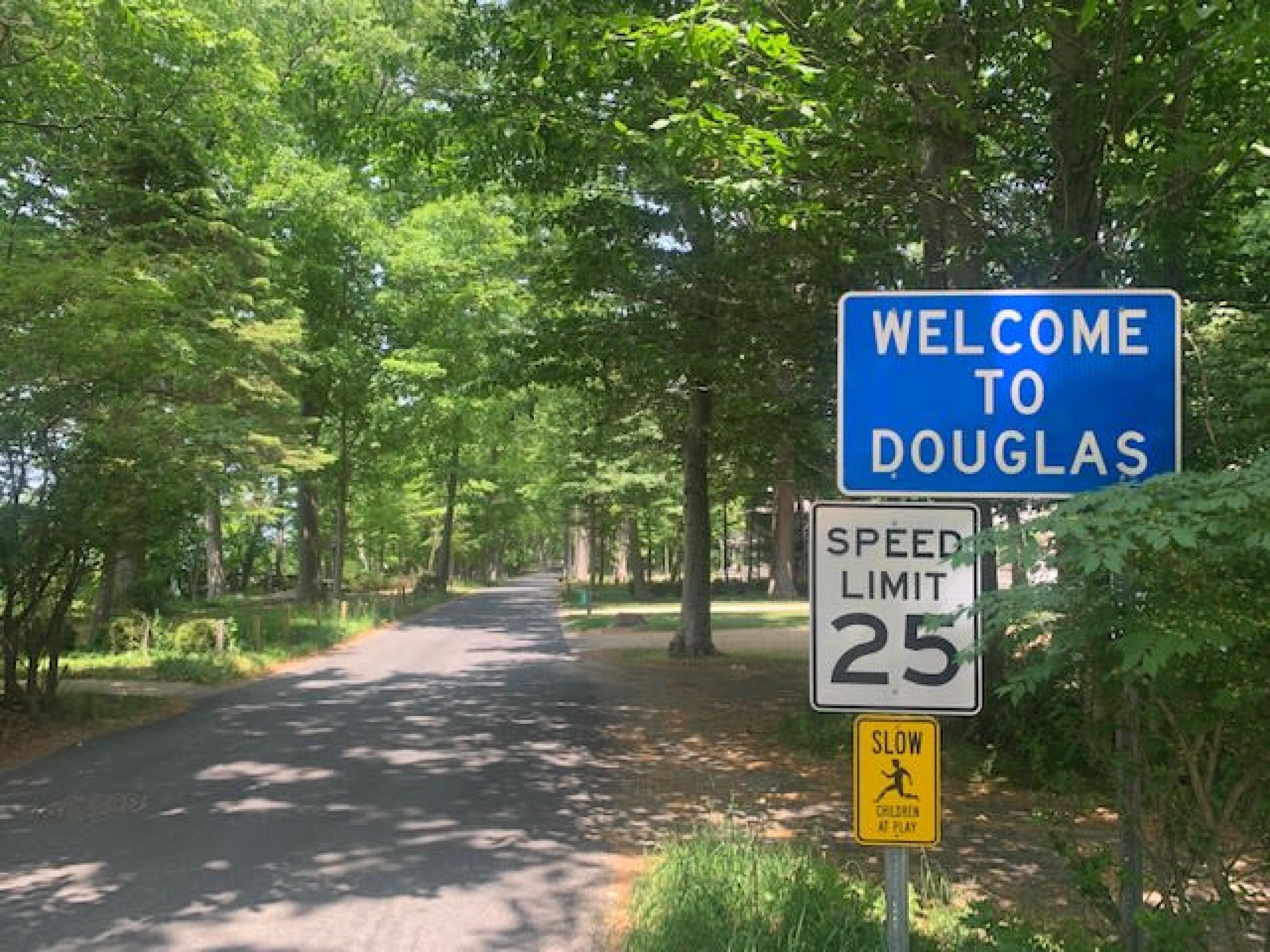 Eine Straße mit einem Geschwindigkeitsbegrenzungsschild und einem Willkommensschild für Douglas.