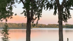 A lakeside view with a gazebo, chairs, and a grill. - Miner Lake Lakefront Beach Cottage for Family Fun (Allegan)