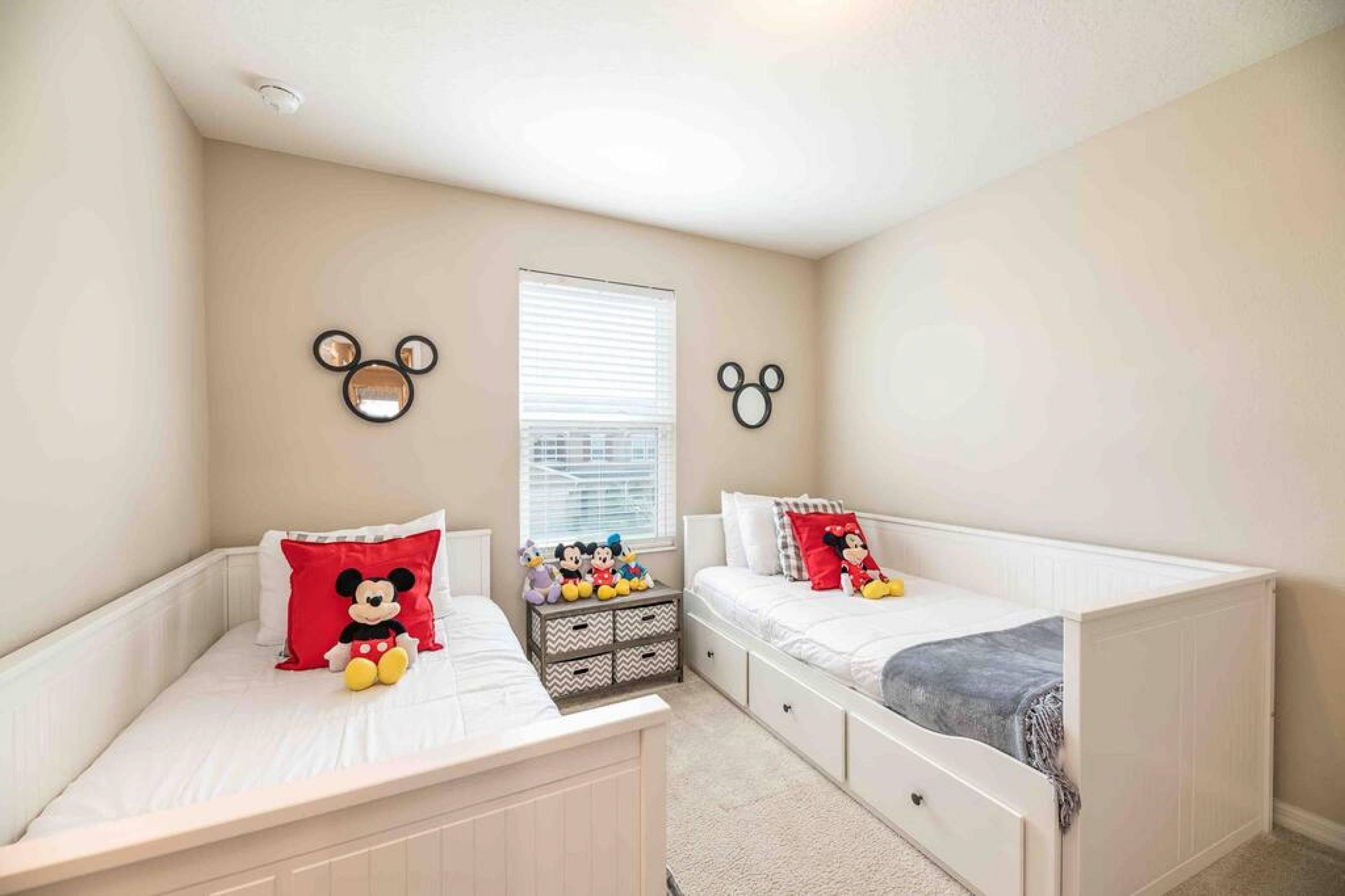 Un dormitorio con dos camas individuales, una ventana con persianas y adornos en la pared, incluyendo caras de osos.