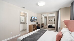 A modern hotel room with a large bed, a TV, a mirror, and a desk. - Super Close- Disney s Parks w Theme Rooms Pool (Lake Buena Vista)