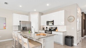 A modern kitchen with white cabinets, granite countertops, and stainless steel appliances. - Super Close- Disney s Parks w Theme Rooms Pool (Lake Buena Vista)