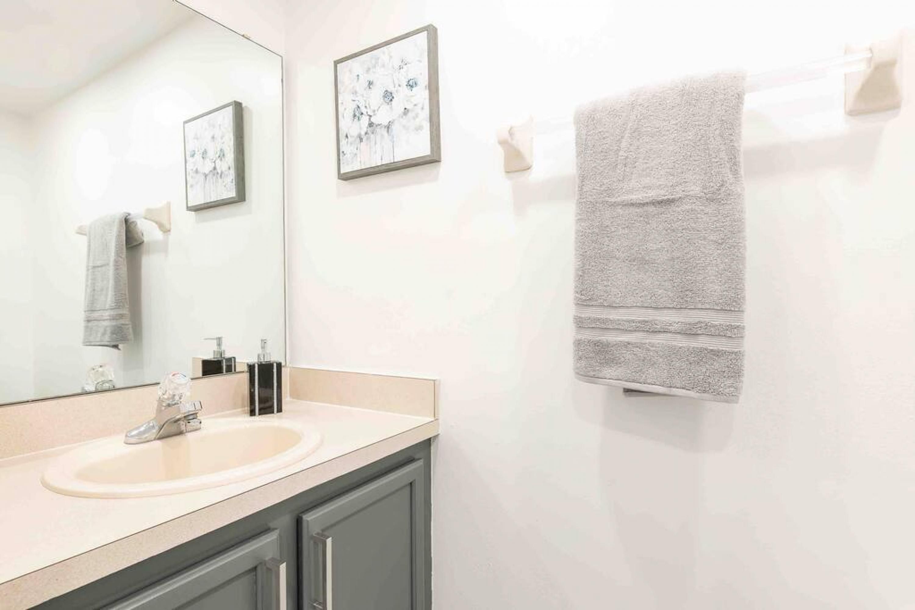 Ein Badezimmer mit Waschbecken, Spiegel und Handtuchhalter.