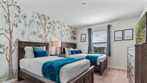 A bedroom with two beds, a dresser, and a window with blinds. - Super Snug- FUN Themes Pool Tons OF Amenities (Kissimmee)