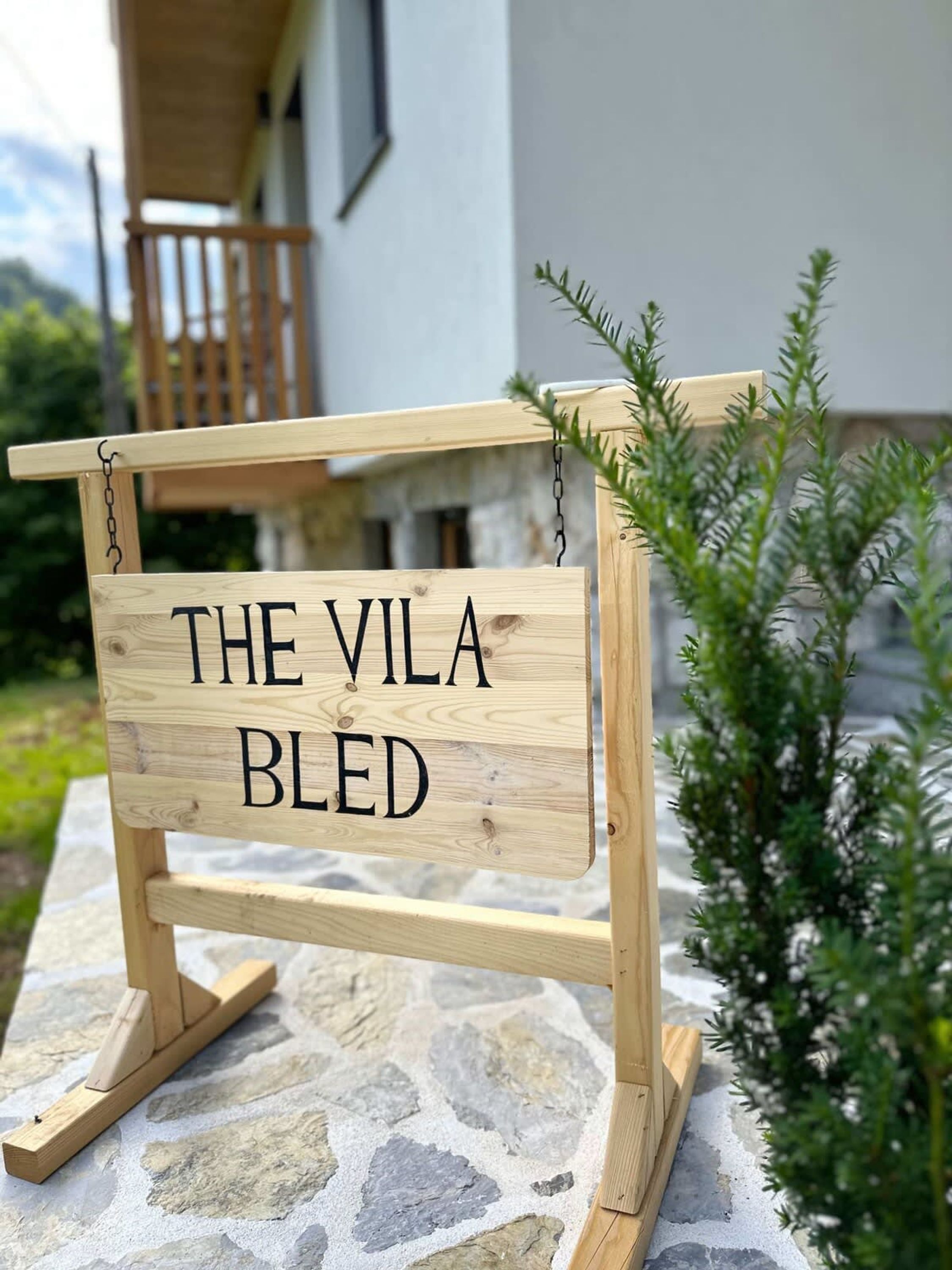 Un senyal de fusta amb el text 'THE VILA BLED' muntat sobre un suport de fusta senzill.