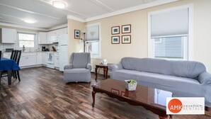 A spacious living area with a dining table, a gray sofa, and a wooden coffee table. - Rest and Relaxation Z s at Slayton Lake (Belding)