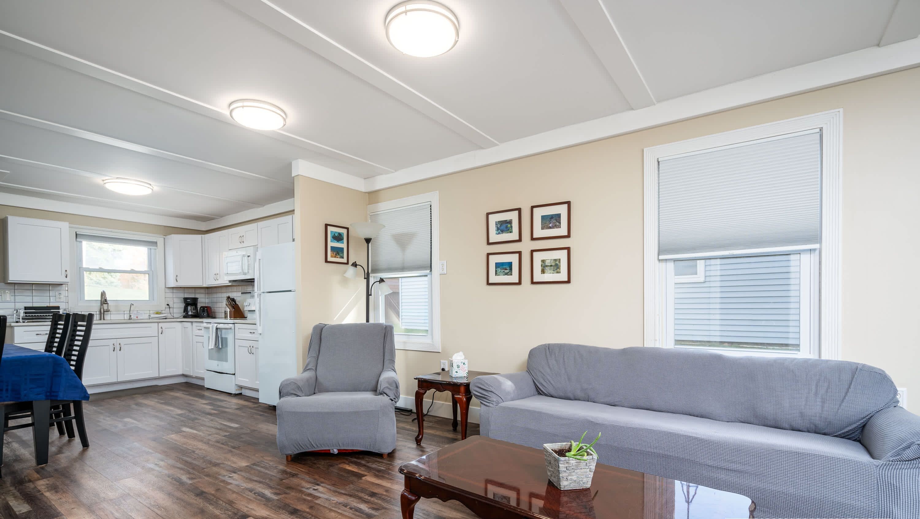 A spacious living area with a dining table, a gray sofa, and a wooden coffee table.