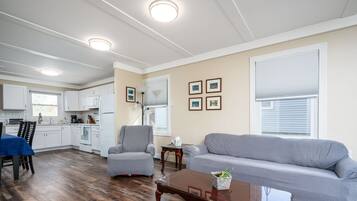 A spacious living area with a dining table, a gray sofa, and a wooden coffee table.