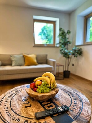 Een houten tafel met een fruitschaal en een afstandsbediening.