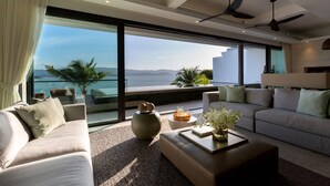 Un salon moderne doté d’une grande fenêtre offrant une vue panoramique, d’un canapé, d’une table basse et d’un vase décoratif.