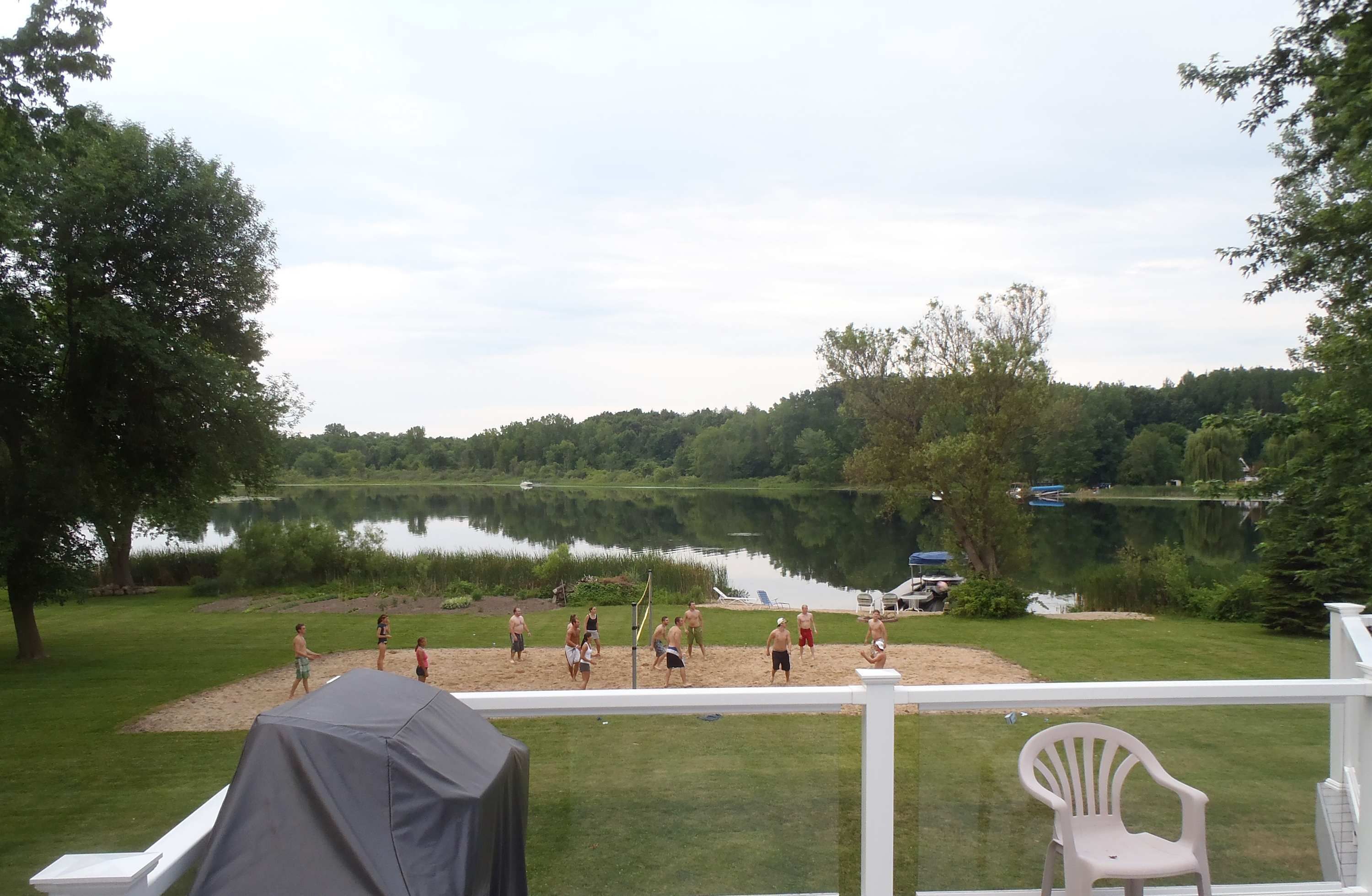 Terraza junto al lago con vista a un lago tranquilo y follaje circundante.