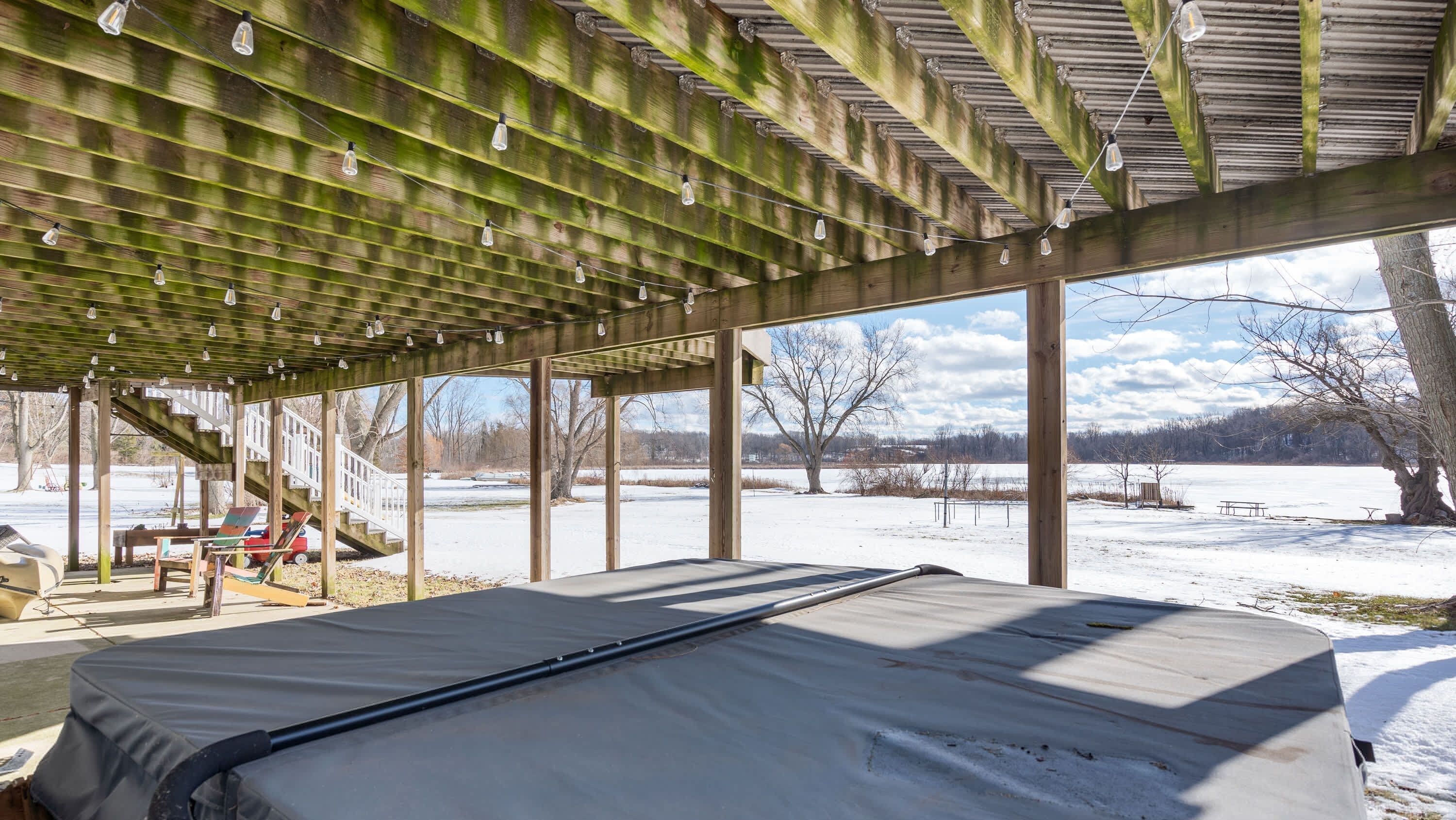 A covered outdoor seating area with a view of a snowy landscape.
