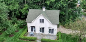 A white house with a gabled roof, surrounded by lush greenery and a well-maintained lawn. - Downtown Douglas Coach House (Douglas)
