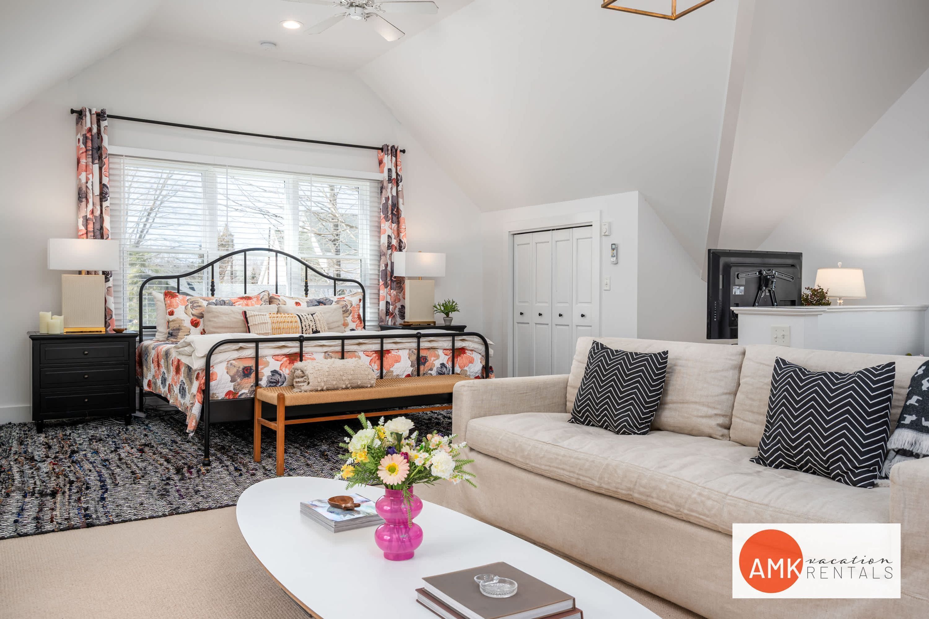 A modern bedroom with a bed, bedside tables, a sofa, and a coffee table.