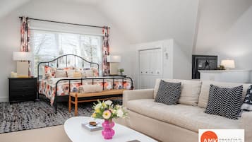 Un dormitorio moderno con cama, mesitas de noche, sofá y mesa de centro.