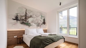 A bedroom with a large bed, a wooden headboard, a white rug, and a painting of trees on the wall. - So a Valley Suites - Superior Apartment 09 (Bovec)