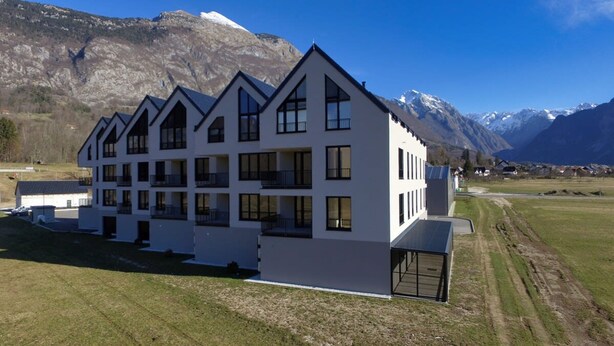 A modern multi-story building with a symmetrical facade, large windows, and a flat roof. - So a Valley Suites - Superior Apartment 09 (Bovec)