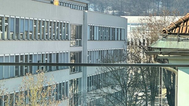Ein Essbereich mit Blick auf ein Gebäude mit vielen Fenstern und eine Burg im Hintergrund.
