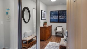 A hallway with a wooden bench, a dresser, and a chair. - Mammoth Rock Oasis-1 bd 1ba Hot Tub Free Pets (Sedona)
