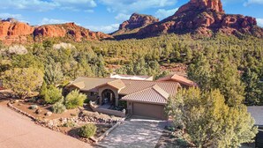 A house with a tiled roof, surrounded by trees and a mountain in the background. - Mammoth Rock Oasis-1 bd 1ba Hot Tub Free Pets (Sedona)