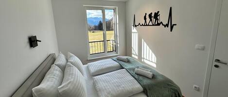 Un dormitorio con cama, ventana, una obra de arte en la pared y una puerta.