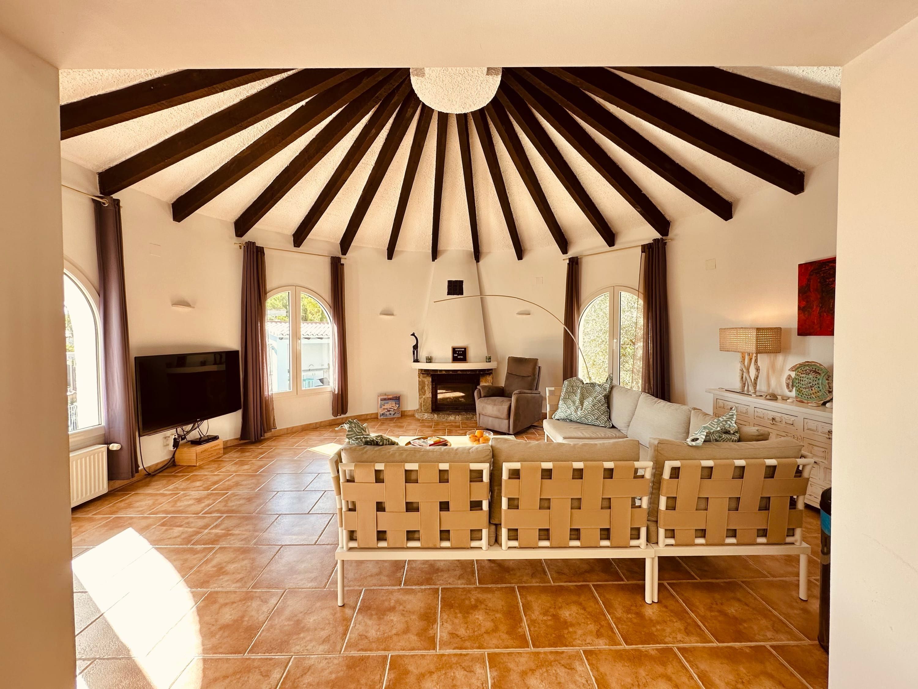 A spacious living area with a fireplace, comfortable seating, and a television.