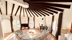Un salón amplio con un sofá grande, una chimenea y un televisor.