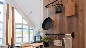 A modern kitchen with wooden walls, a hanging pot rack, and a welcome sign. - So a Valley Suites - Superior Apartment 28 (Bovec)