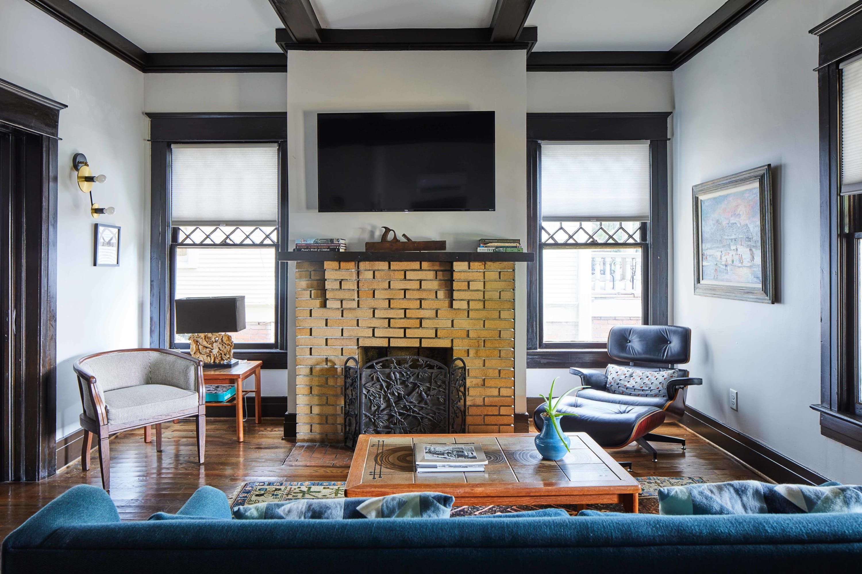 Una sala de estar con chimenea de ladrillo, un televisor de pantalla plana, un sofá y una mesa de centro.