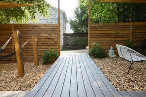 A wooden deck with a hammock, a statue, and a chair. - Apt1 Charles - Step-free Accessible Dog-friendly (Birmingham)