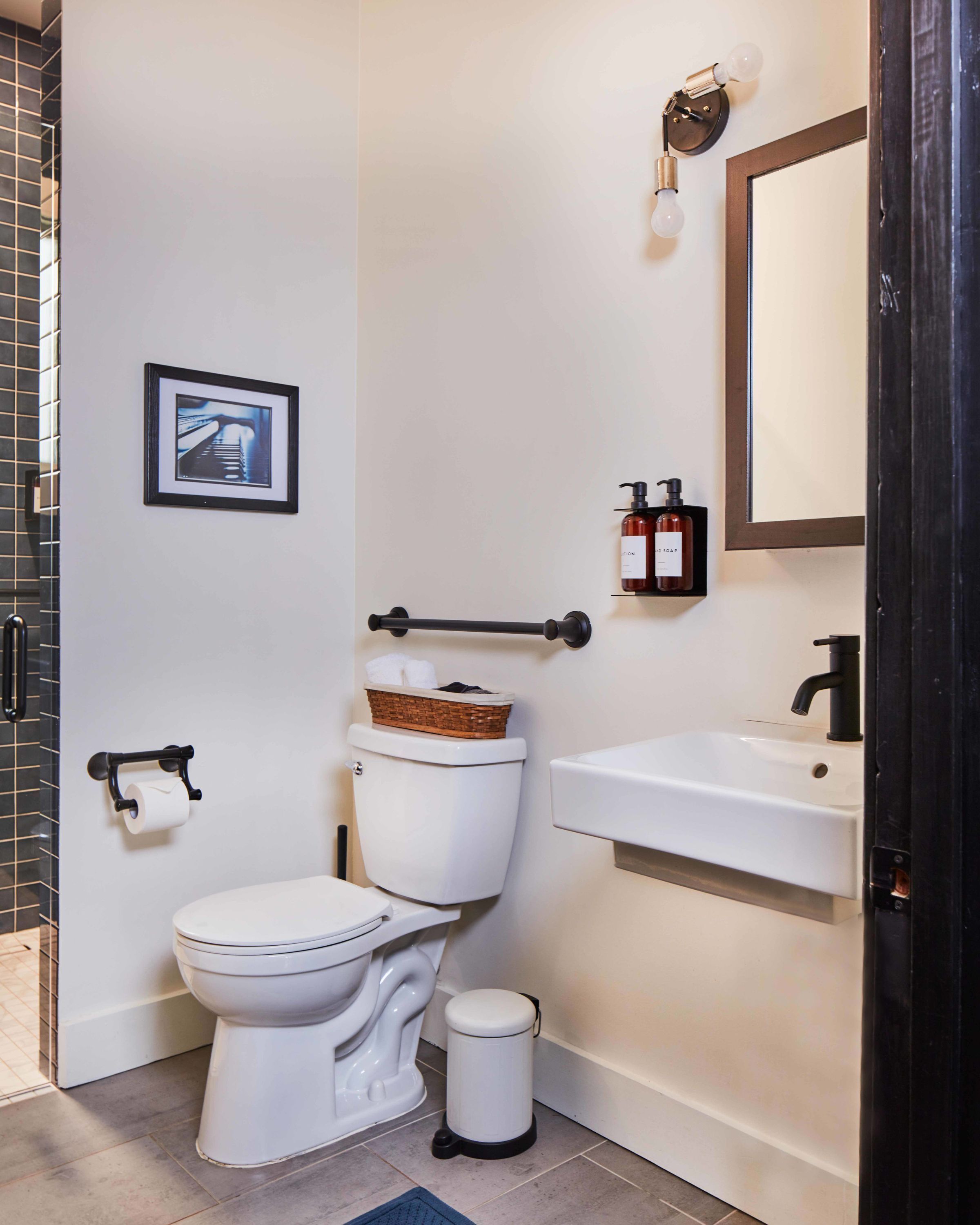 Ein modernes Badezimmer mit Toilette, Bidet, Waschbecken und Mülleimer.