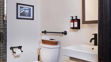 Ein modernes Badezimmer mit Toilette, Bidet, Waschbecken und Mülleimer.