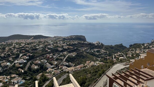 A coastal town with a view of the sea and a hill in the background. - Two Bedroom Apartment With Breath-taking Views (Benitachell)